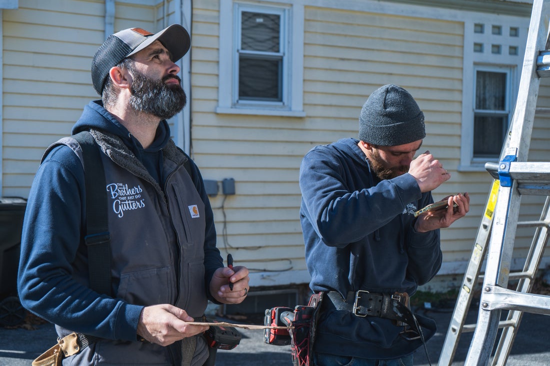 Two Hudson Valley crew members planning a gutter install
